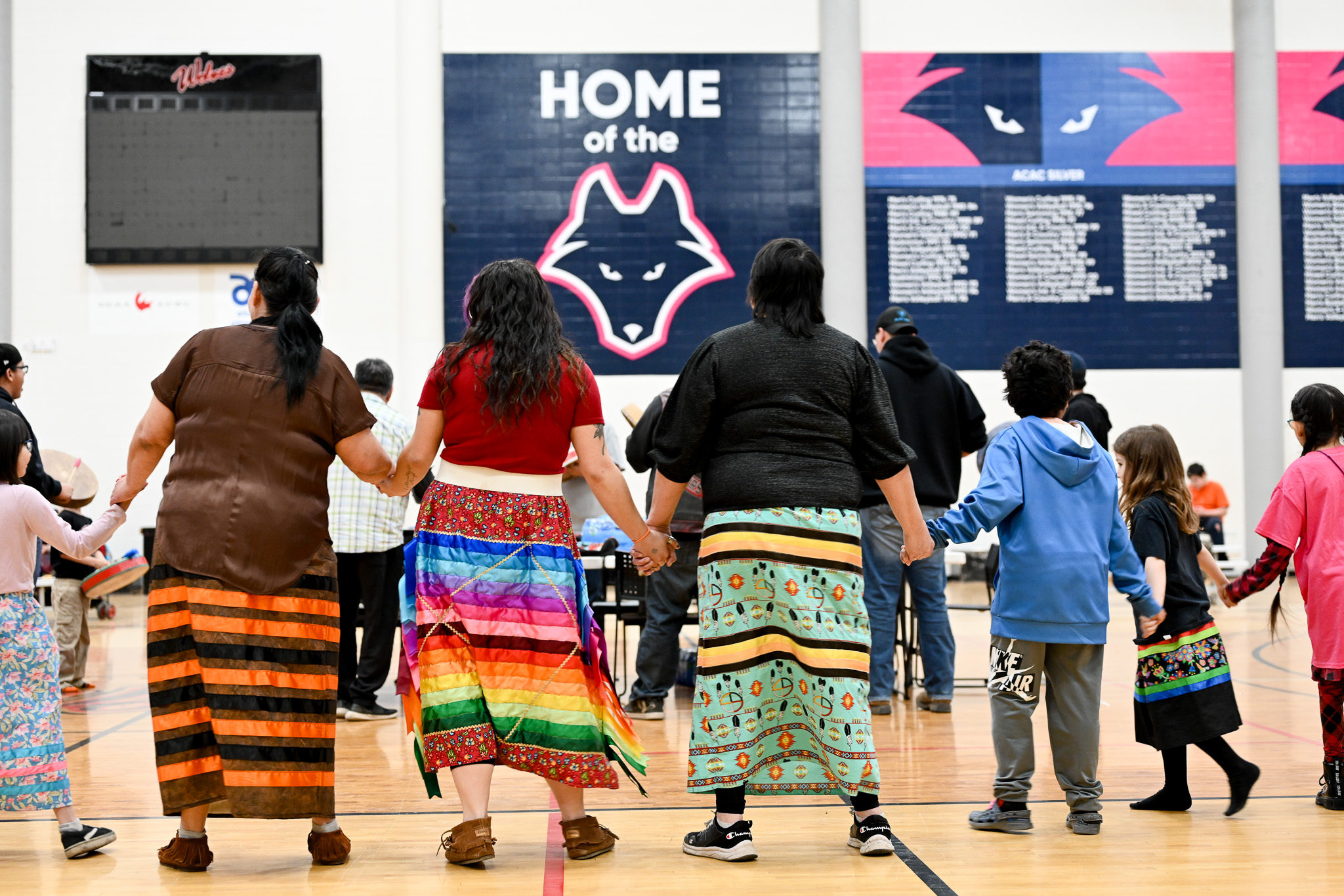 Dancers with colourful skirts holding hands at the Circle of Indigenous Students year end event