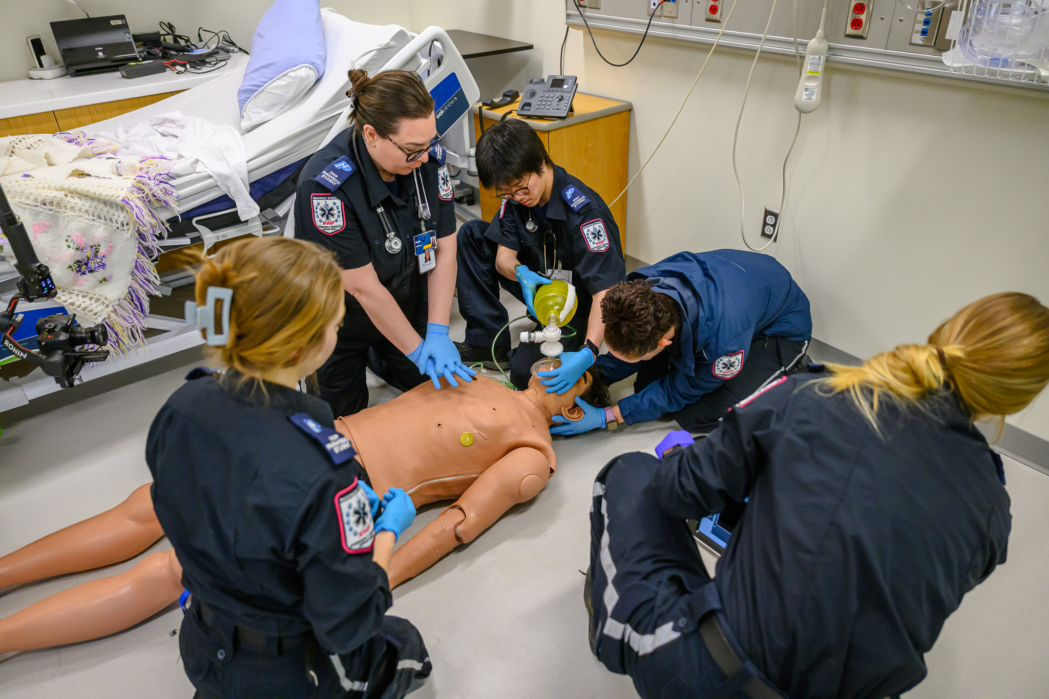 Students in emergency services providing CPR to a dummy in the simulation lab