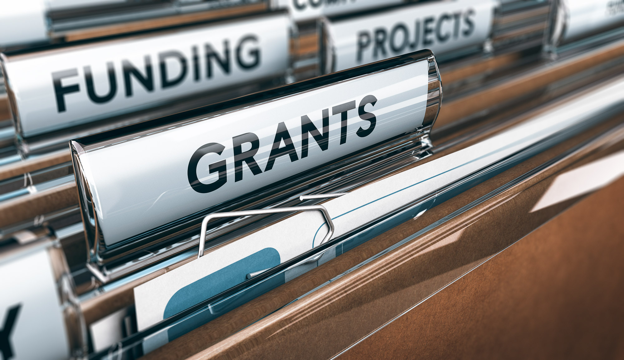 An open office drawer of folders with labels featuring titles that say grants, funding and projects.