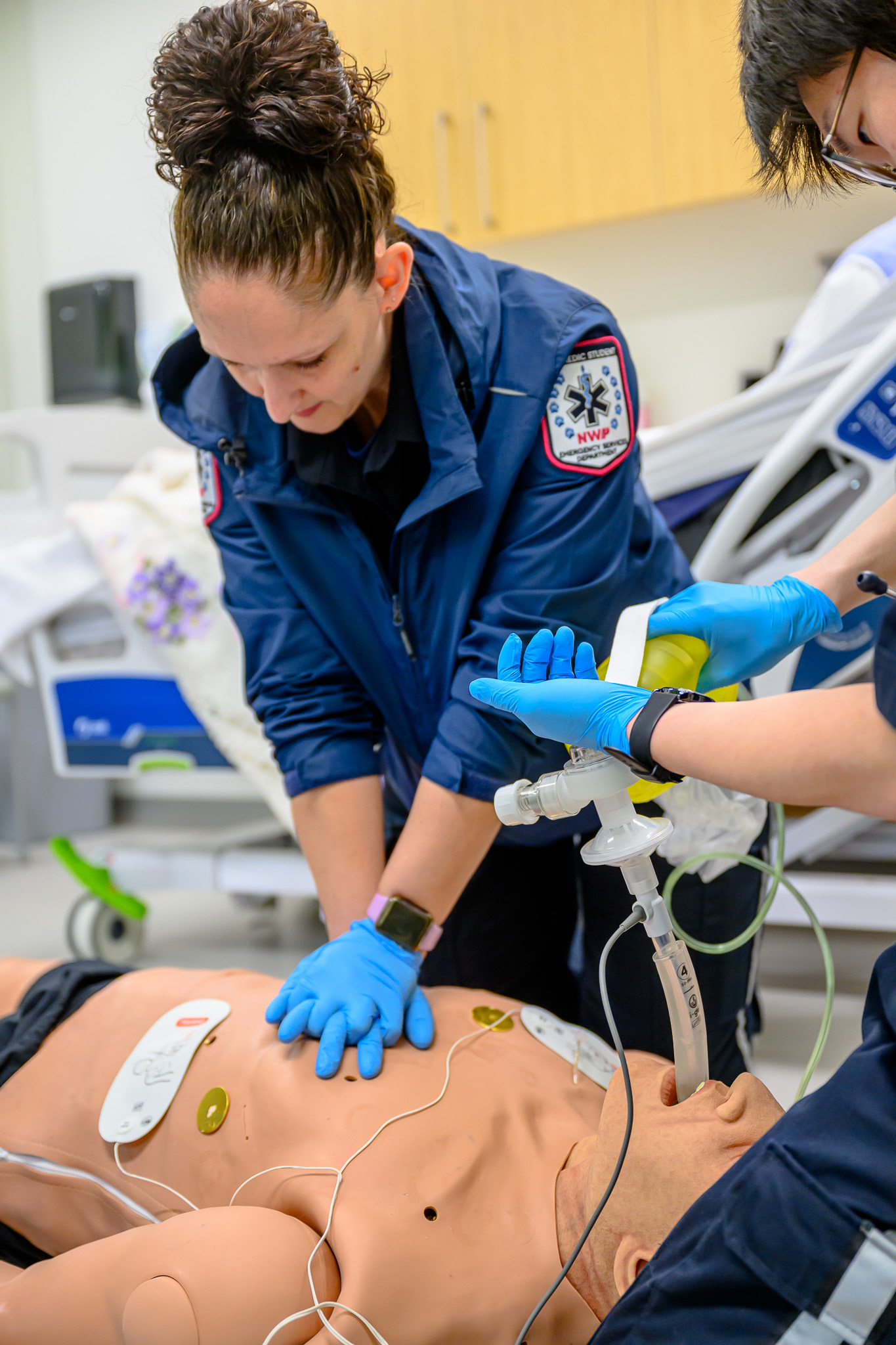 An emergency services student performing cardiopulmonary resuscitation on a dummy patient in the simulation lab at NWP