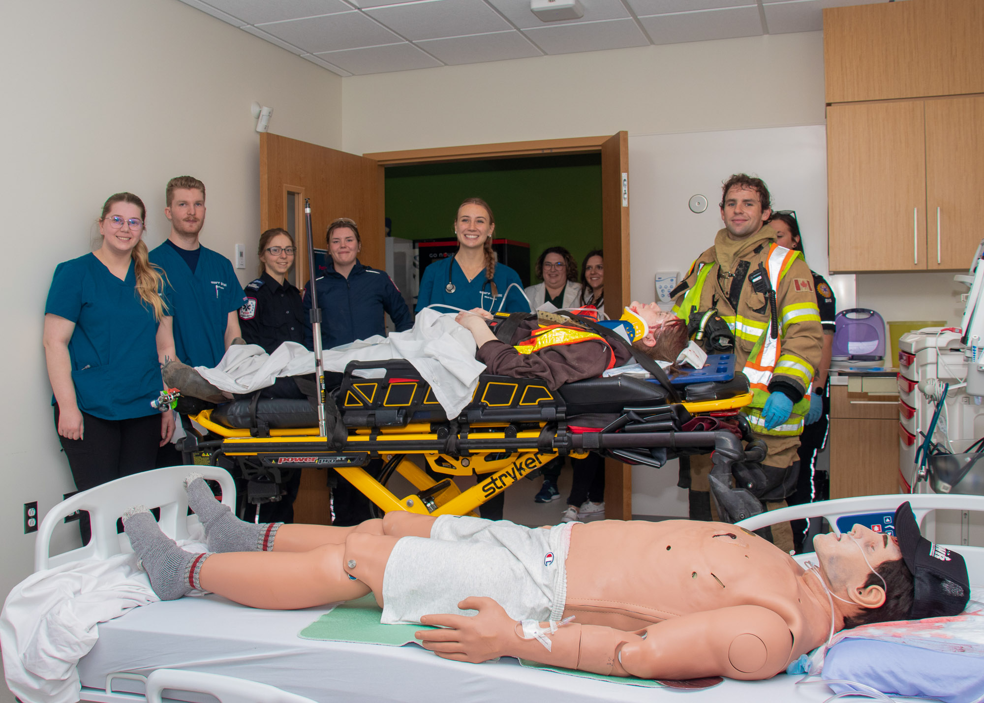 Group photo of healthcare professionals, student nurses, and firefighters at a simulation event
