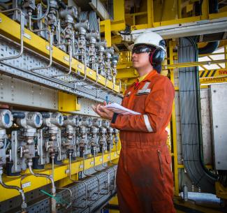 Instrument technician on the job recording data and function checking pressure transmitters