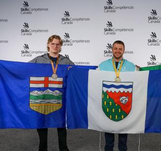Luke Emeny holding up the Alberta flag at Skills Canada competition