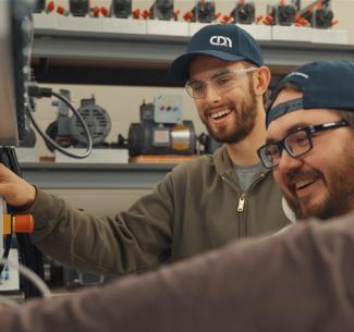 Group of happy electrical students collaborating on a project in the CDN Electrical Education Centre lab