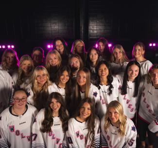 The Wolves Women's Hockey team takes a selfie while wearing their jerseys.