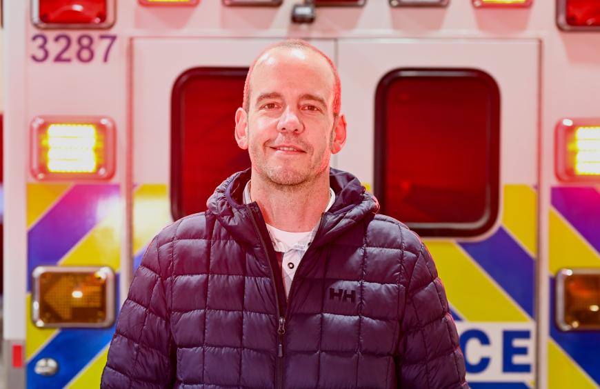 Luke Umble, emergency services instructor posing in front of an ambulance