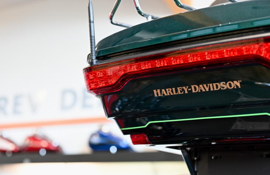 Close up of the rear of a Harley Davidson motorcycle gleaming under showroom lights.