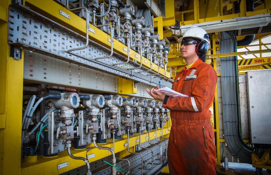 Instrument technician on the job recording data and function checking pressure transmitters