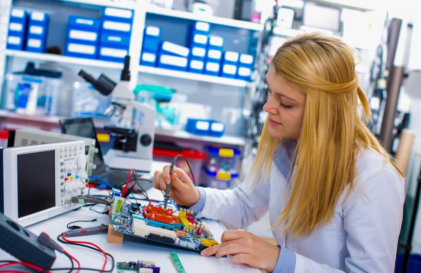 A computing science student in a lab testing the circuit design of a robot