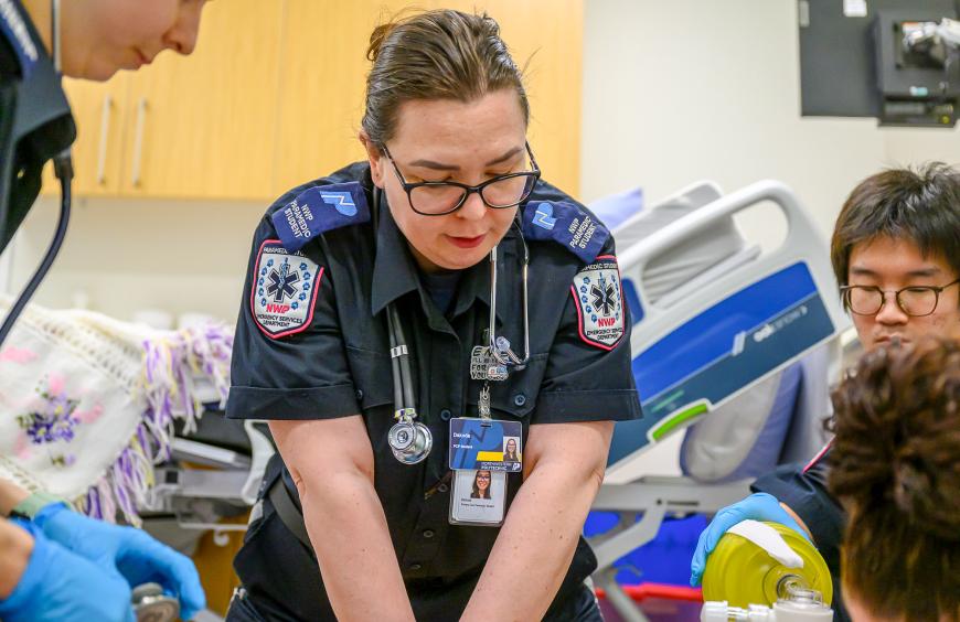 Paramedic student applying CPR to a dummy in the simulation lab