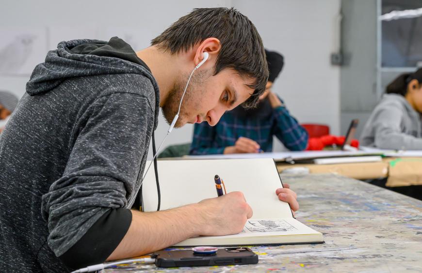 Fine arts student sketching in a notebook