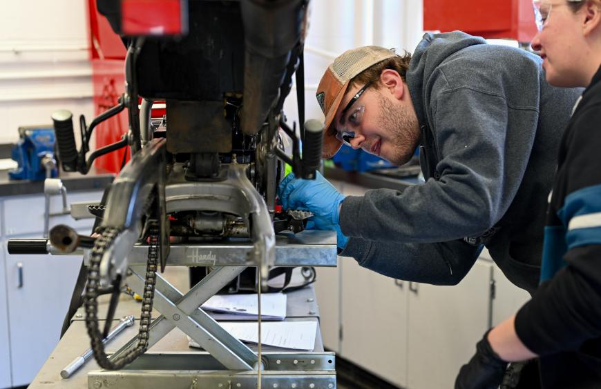 Apprenticeship students working on a motorcycle in the workshop at Fairview 