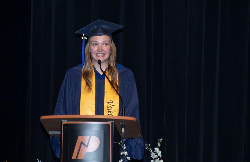 Grace Larsen, 2025 Grande Prairie Valedictorian at the lectern delivering her address to graduates