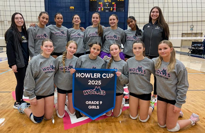The Charles Spencer high school grade 9 girls volleyball squad posing in the NWP gym holding up their championship banner