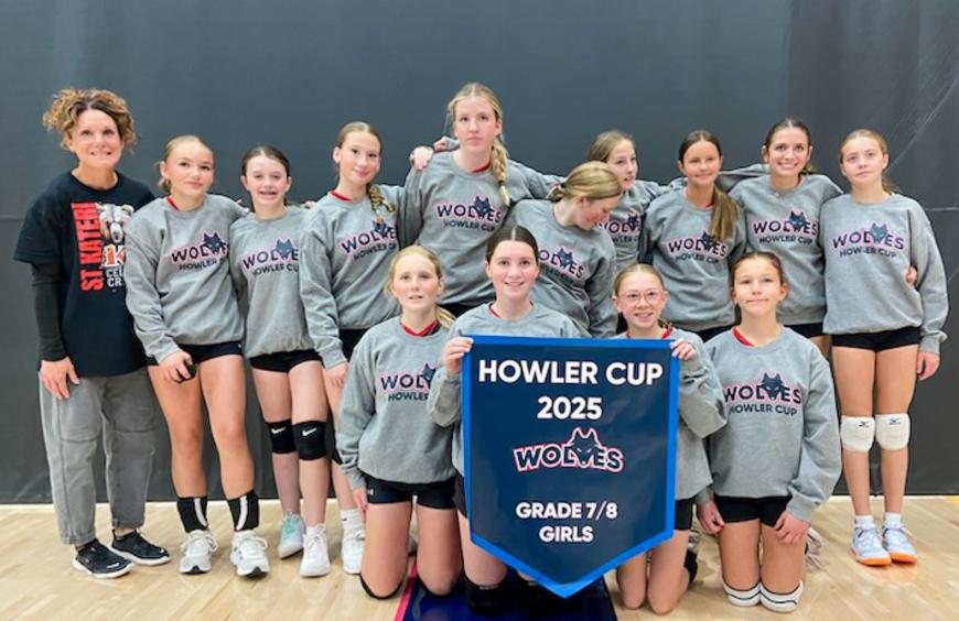 The St. Kateri Catholic School grade 7/8 girls volleyball squad posing in the NWP gym holding up their championship banner