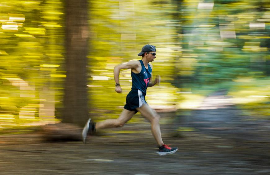 NWP Instructor, Fabio Minozzo in full stride running through a forest in the fall
