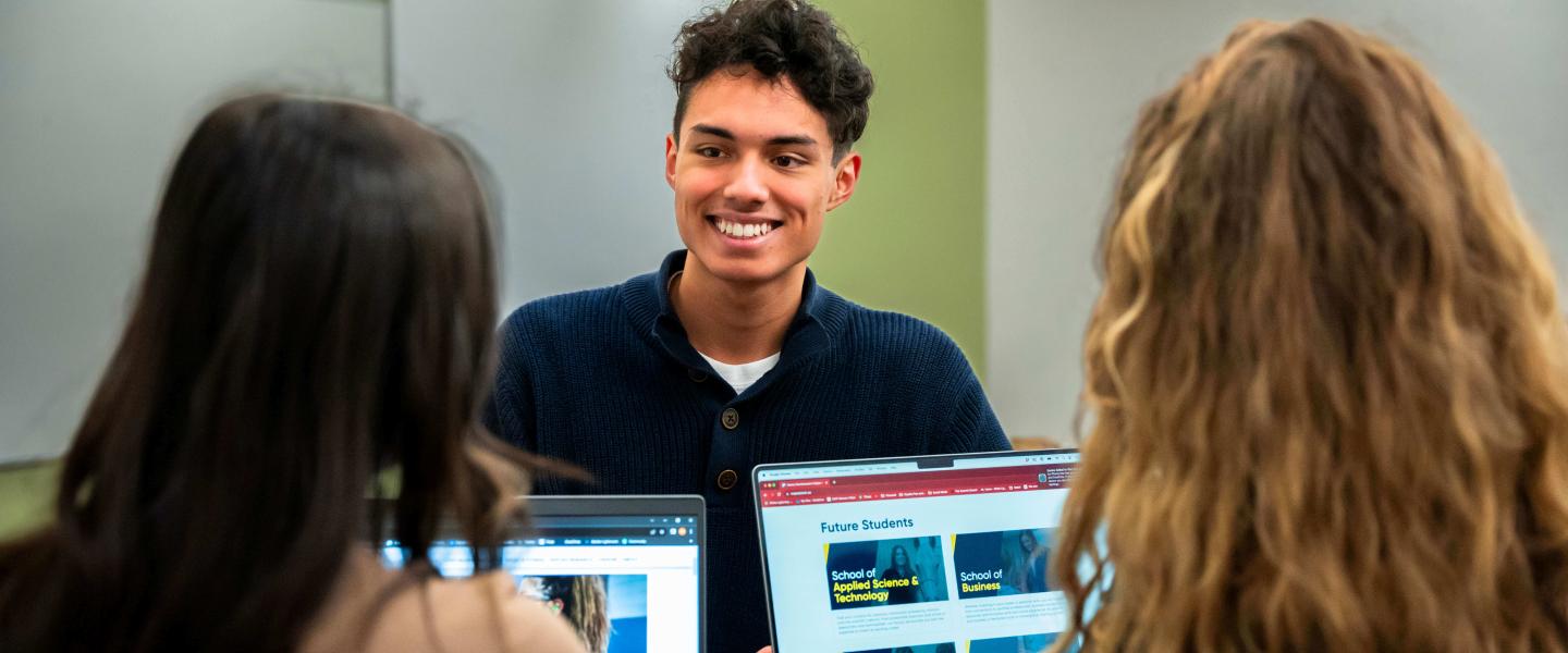 Students chatting at a computer station