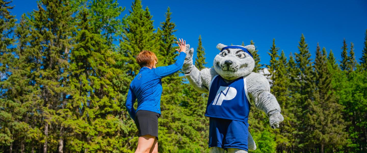 NWP mascot Farley high fiving with a golfer at the NWP classic golf tournament