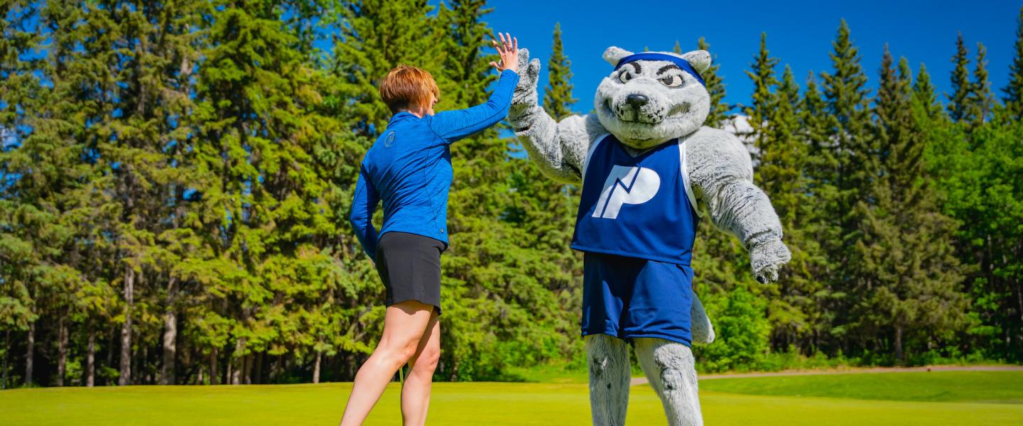 NWP mascot Farley high fiving with a golfer at the NWP classic golf tournament