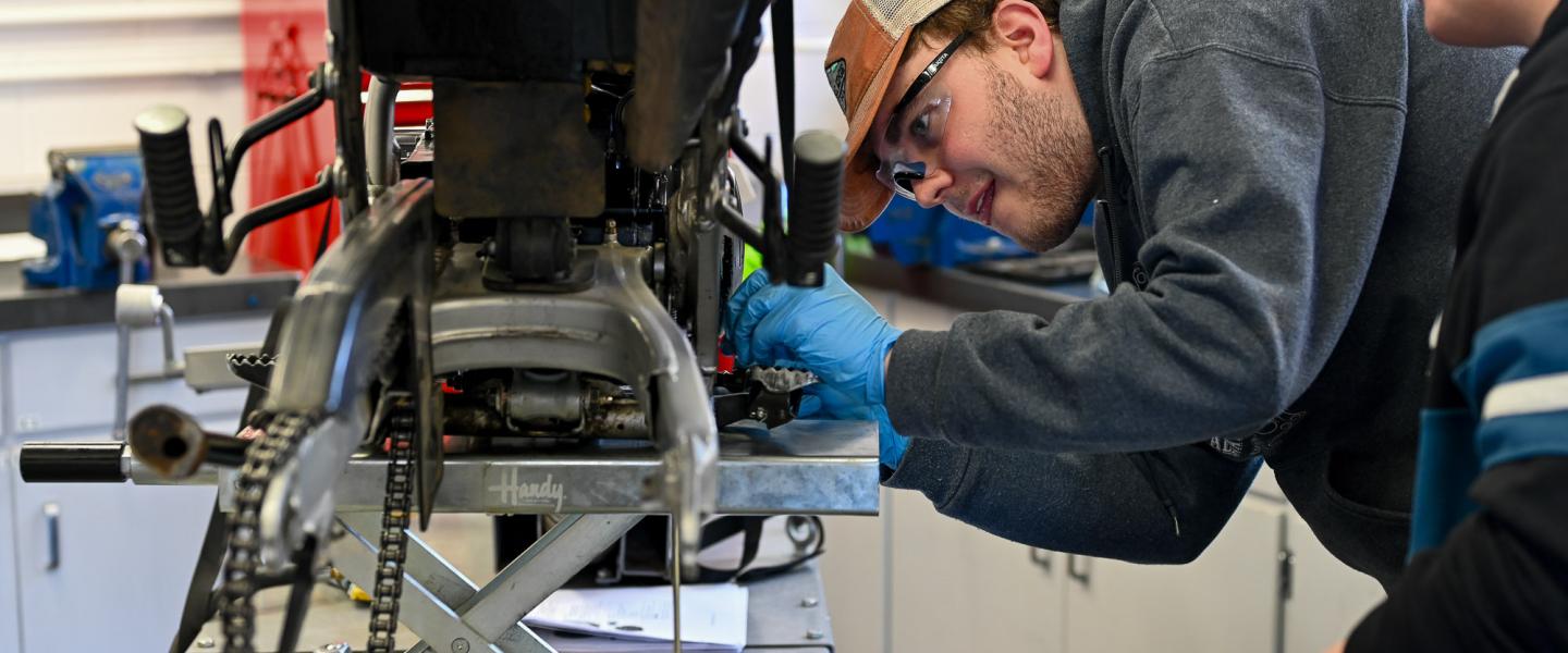 Apprenticeship students working on a motorcycle in the workshop at Fairview 