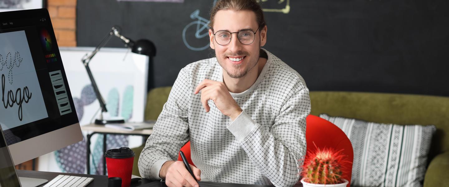 Happy graphic designer at his computer
