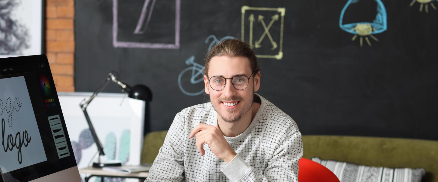 Happy graphic designer at his computer