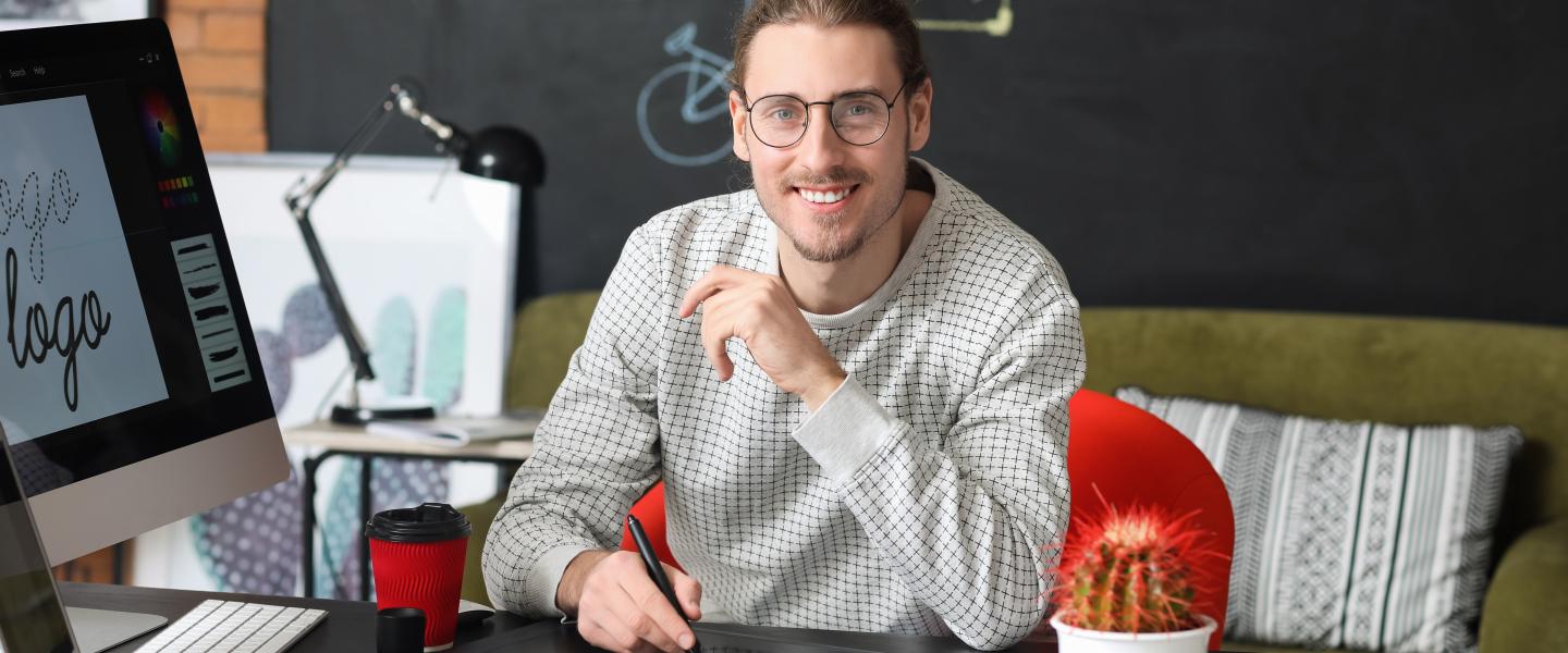 Happy graphic designer at his computer