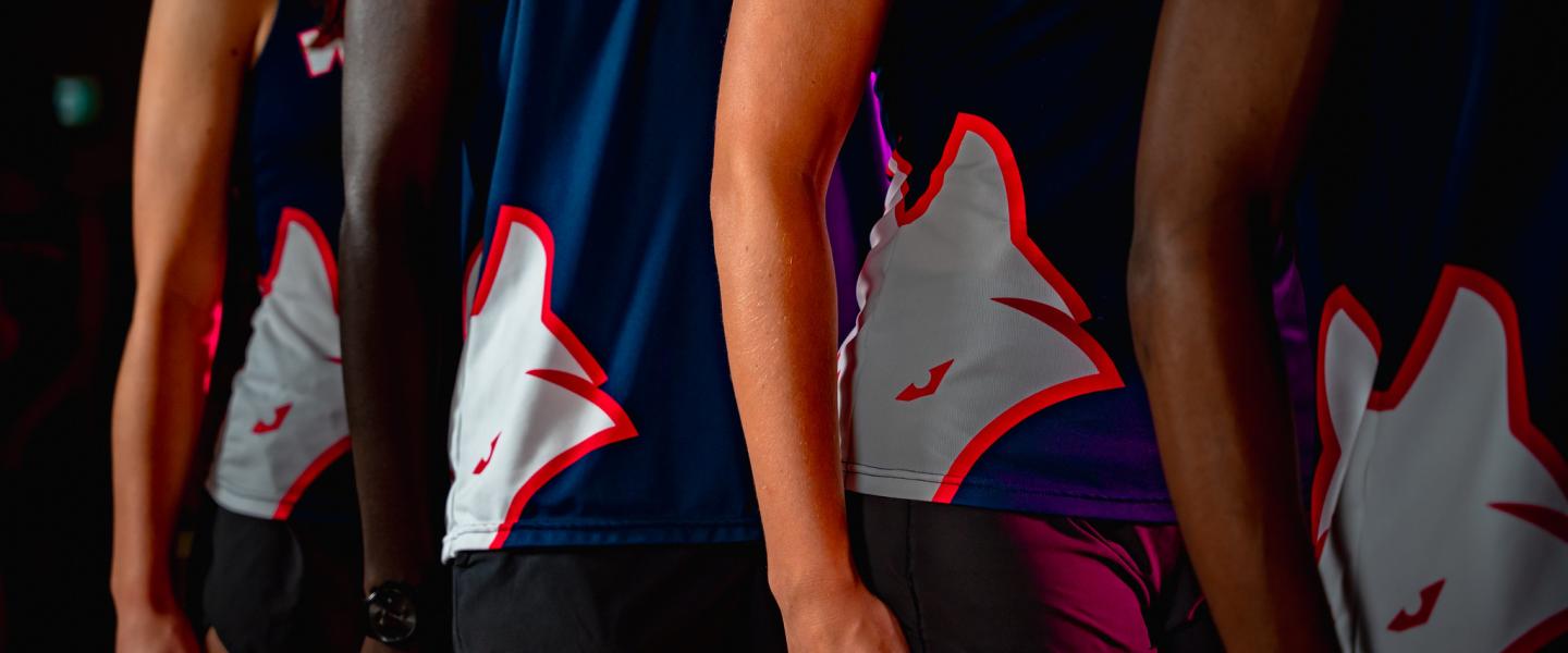 close up photo of the running vests of Wolves cross country athletes in a line