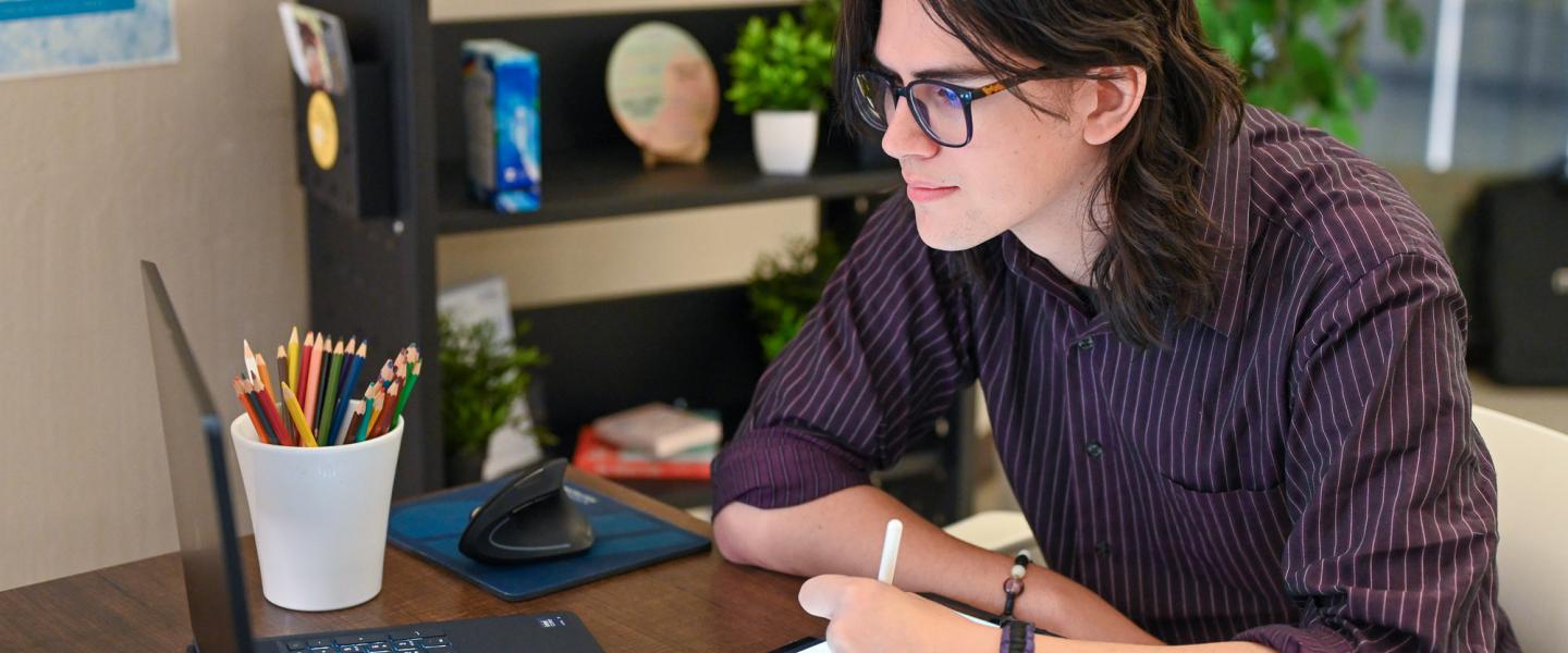 Graphic designer sitting at his desk creating an illustration on an ipad