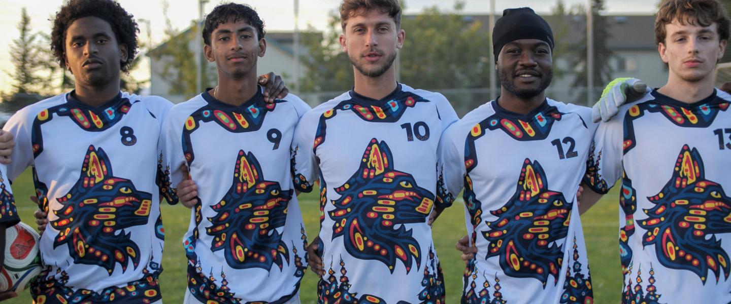 Wolves men’s soccer players line up before a game wearing Indigenous-themed jerseys.