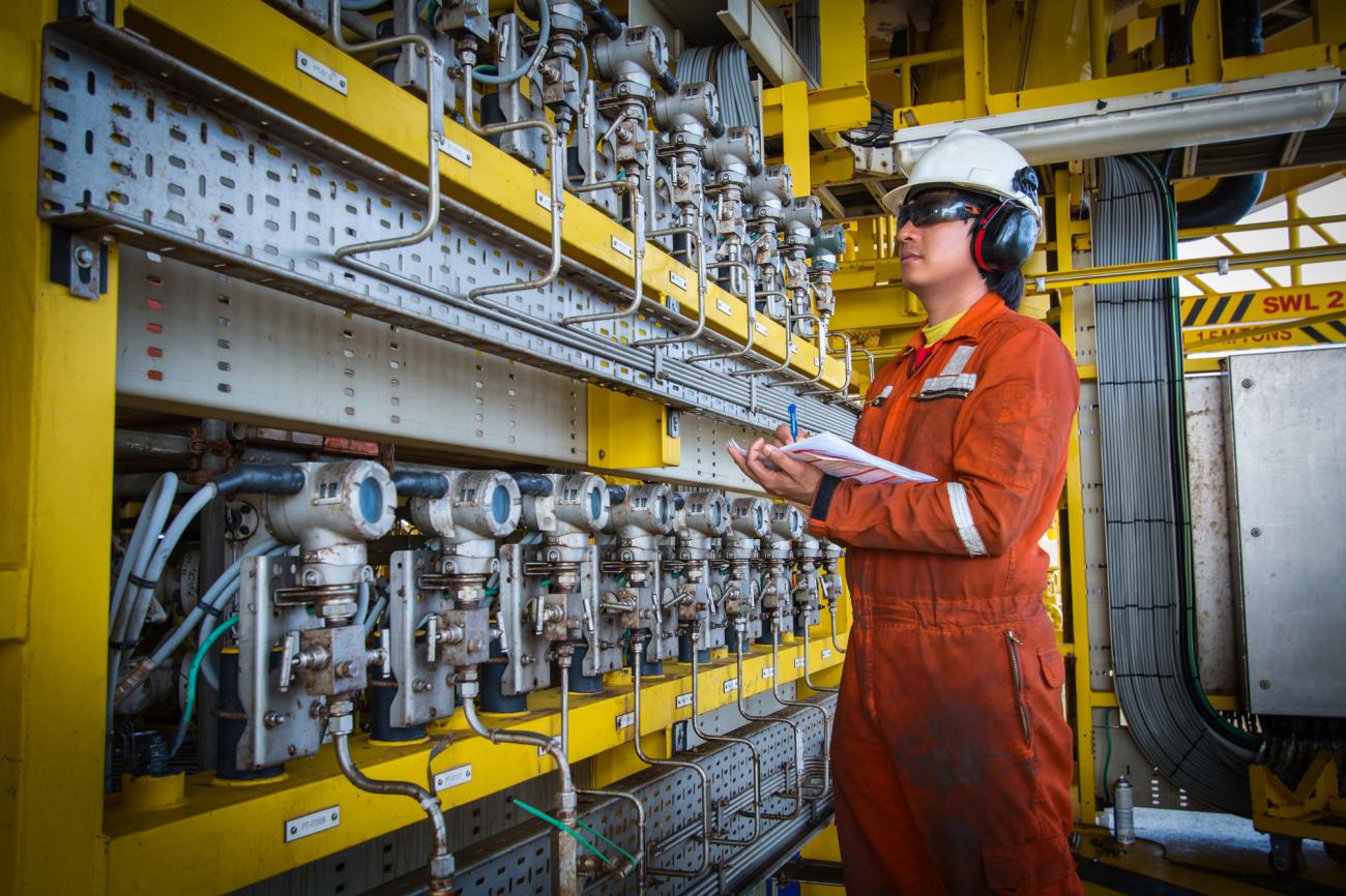 Instrument technician on the job recording data and function checking pressure transmitters