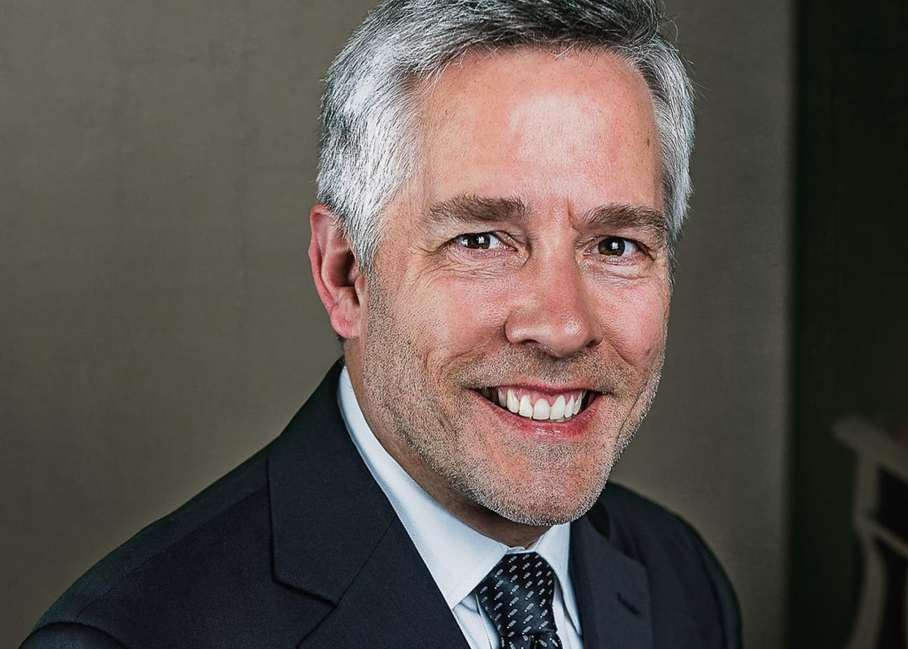 Headshot of a happy Roger Admiral sitting at his piano