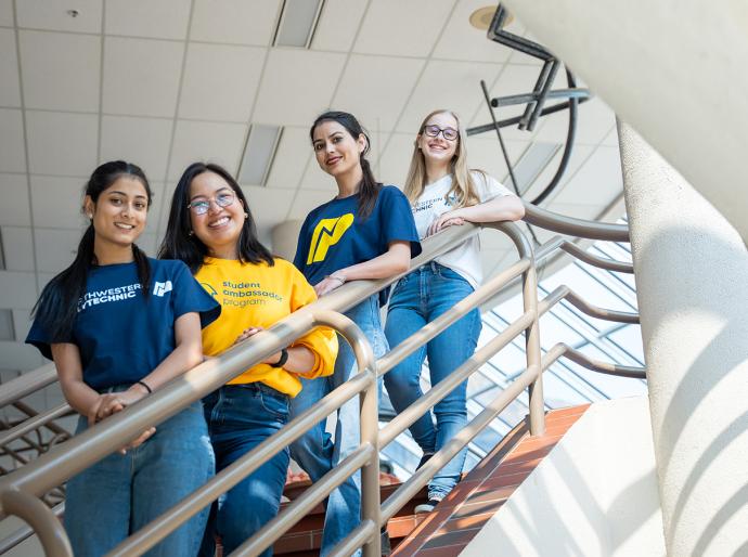 Happy students posing on a spiral staircase