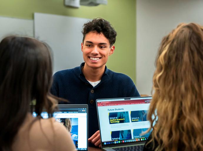 Students chatting at a computer station