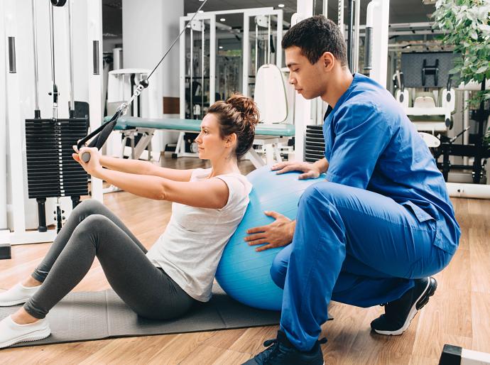 Exercise physiologist helping a client with rehabilitation