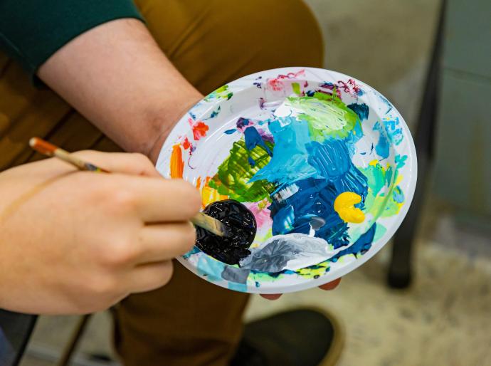 Close up of paintbrush mixing paint