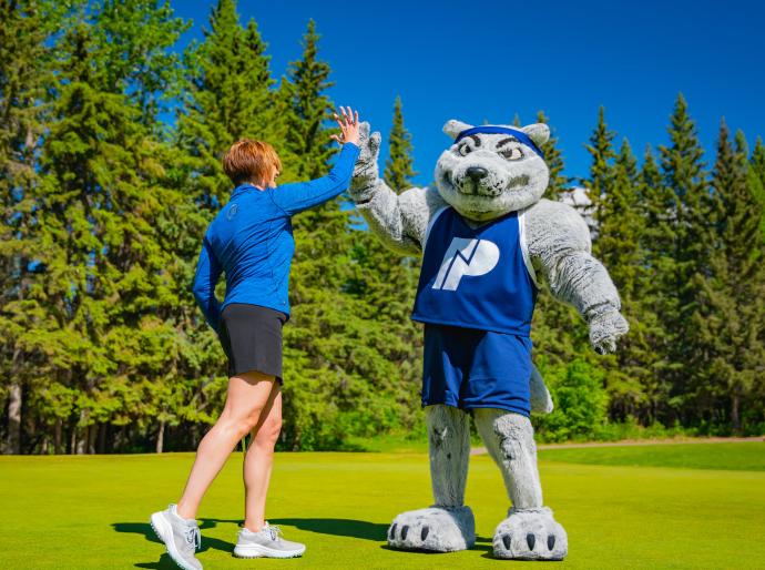 NWP mascot Farley high fiving with a golfer at the NWP classic golf tournament