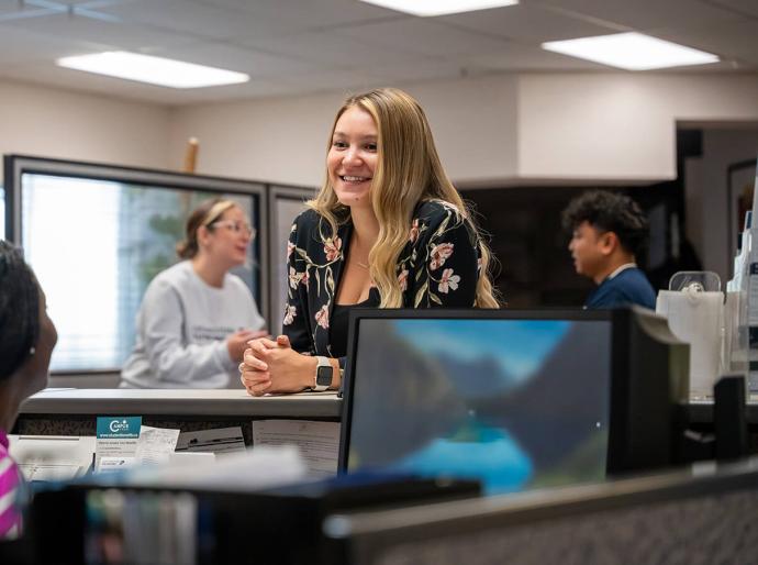 Woman at reception in a busy workplace