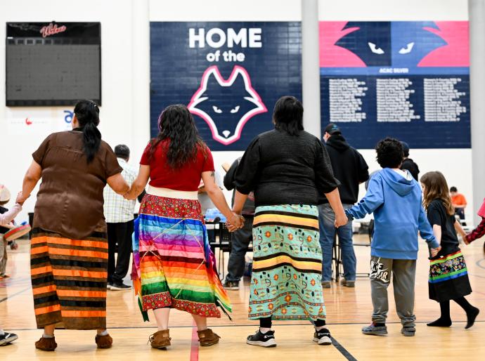Dancers with colourful skirts holding hands at the Circle of Indigenous Students year end event