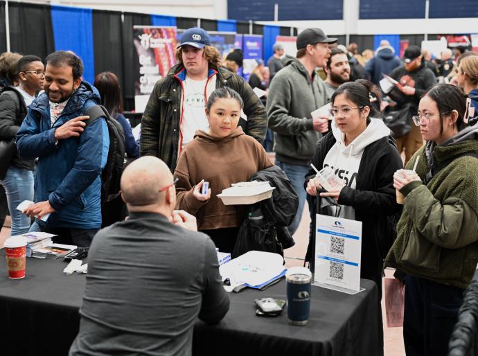 Several attendees talking to a vendor at the 2024 NWP Career Fair