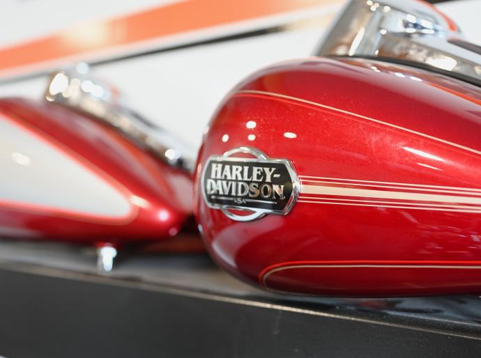 Close up of the Harley Davidson logo on a sleek, shiny red and white motorcycle.