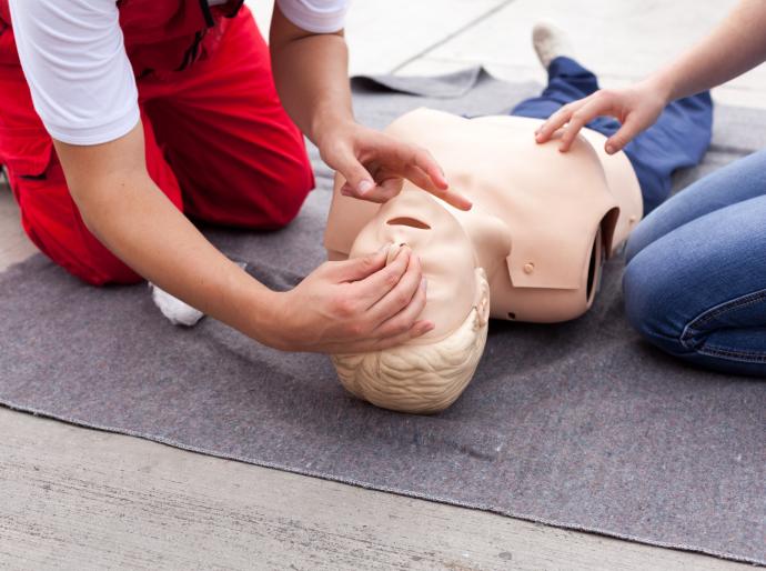 First aid student practicing technique on a dummy