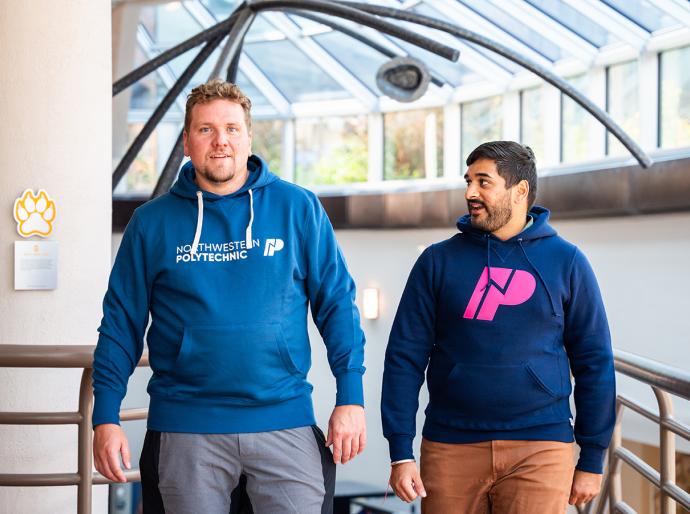 Two happy students walking and talking in a bright hallway