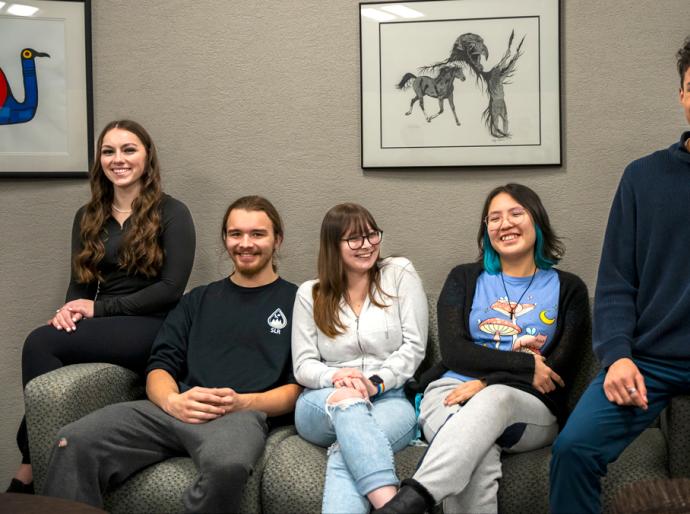 A cheerful group of Indigenous students sitting on a couch in the Friendship Centre