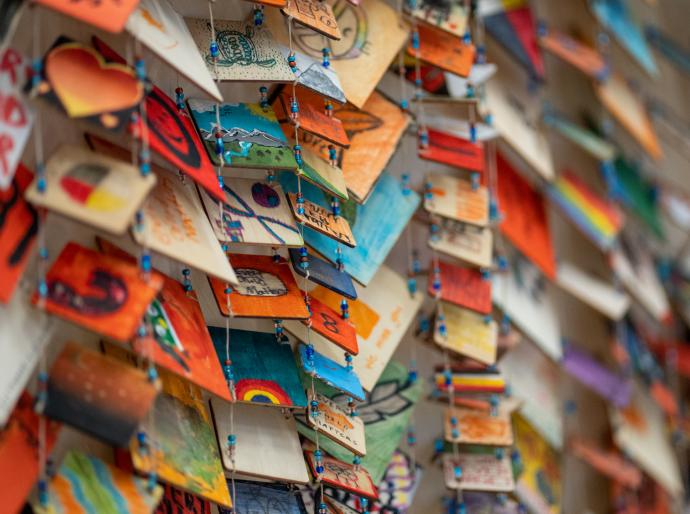 Closeup of little hand made cards strung together to form an art piece in honour of Orange Shirt Day