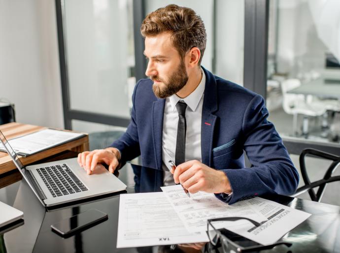 Smartly dressed businessman working at his laptop in a professional office.