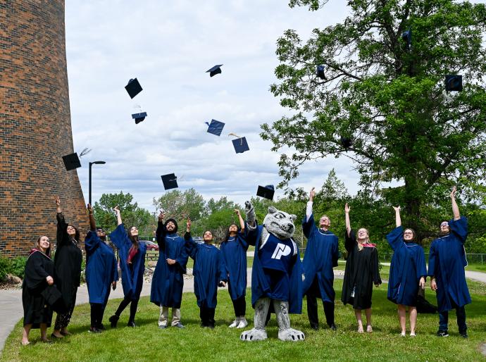 A group of graduates throwing their mortarboards into the air