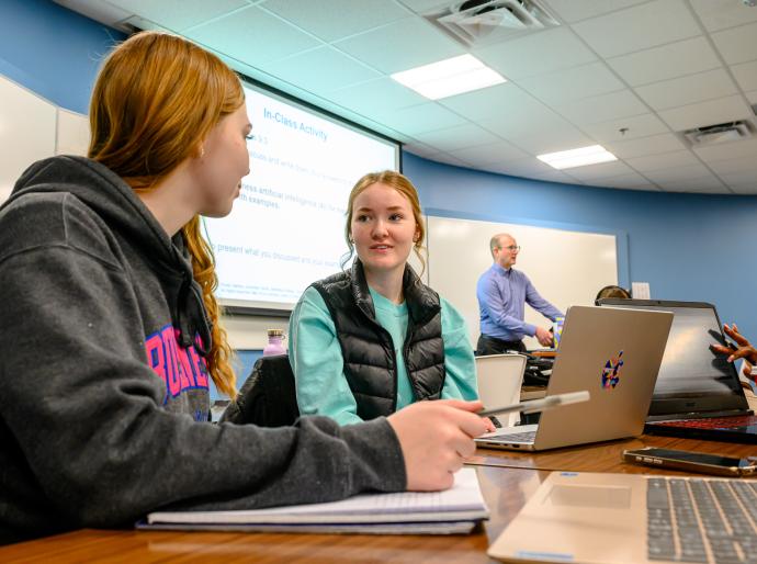 Two students working on a group project in a marketing class