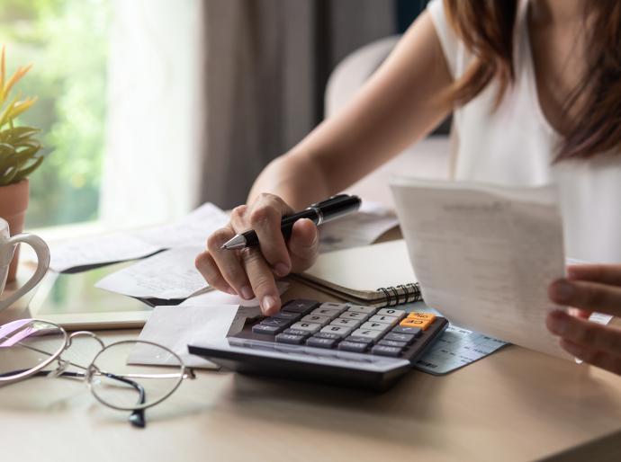Close up of a student using a calculator to pay bills