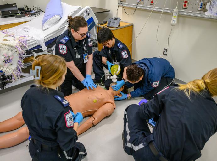 Students in emergency services providing CPR to a dummy in the simulation lab